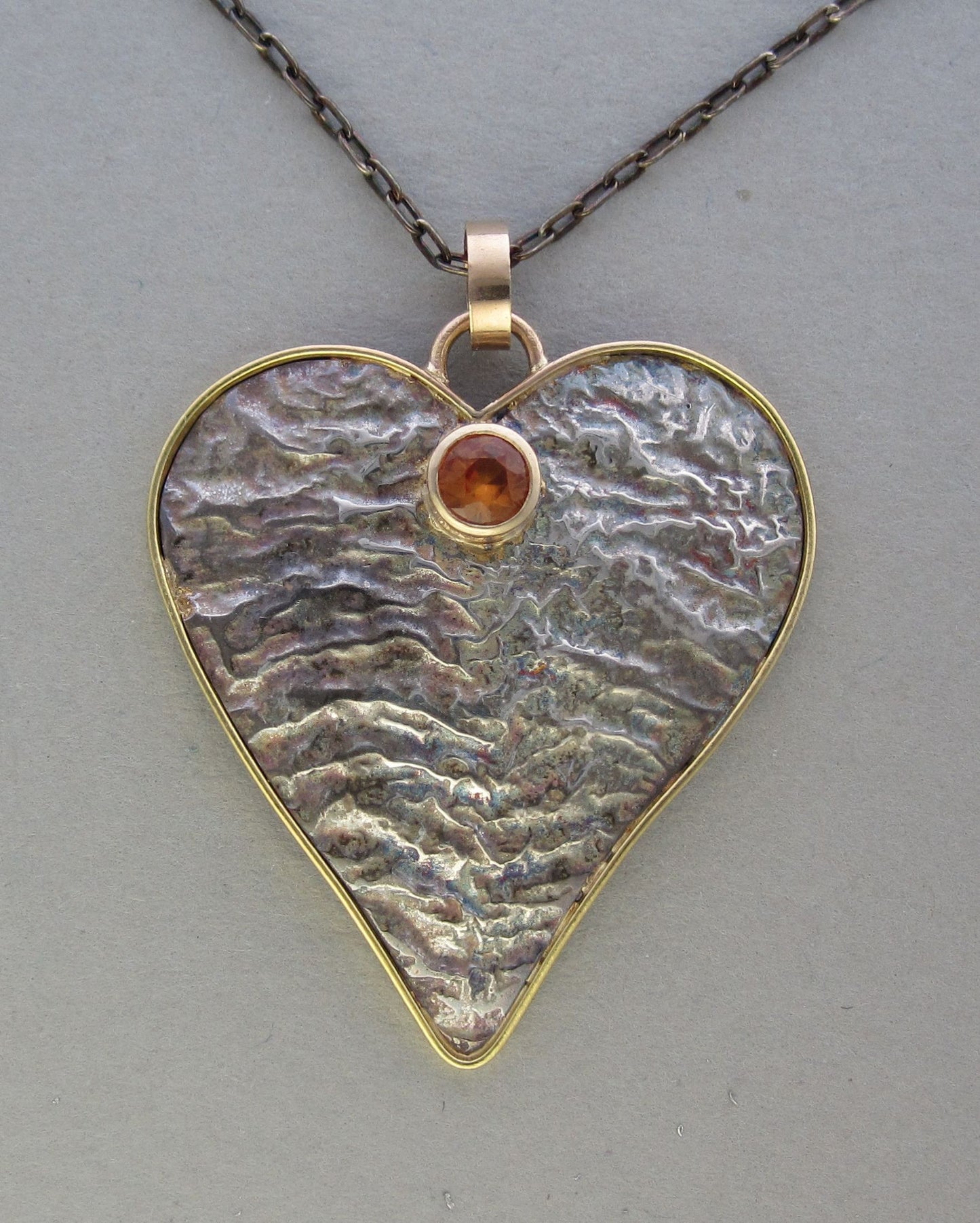 silver reticulated heart pendant with gold and gemstone